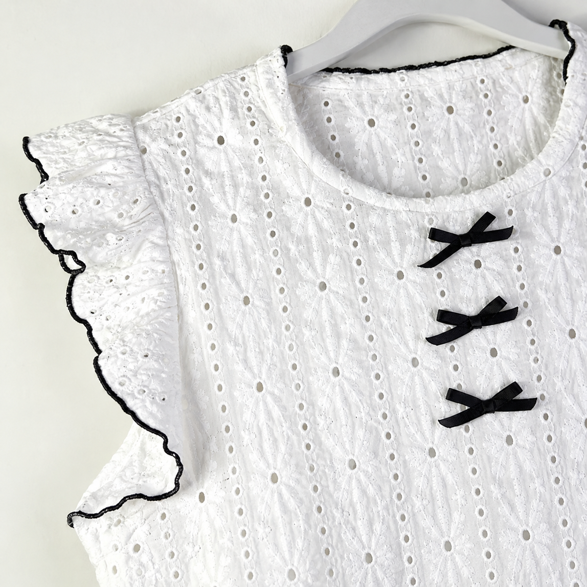Detalle de Pijama blanco de dos piezas con lazos negros